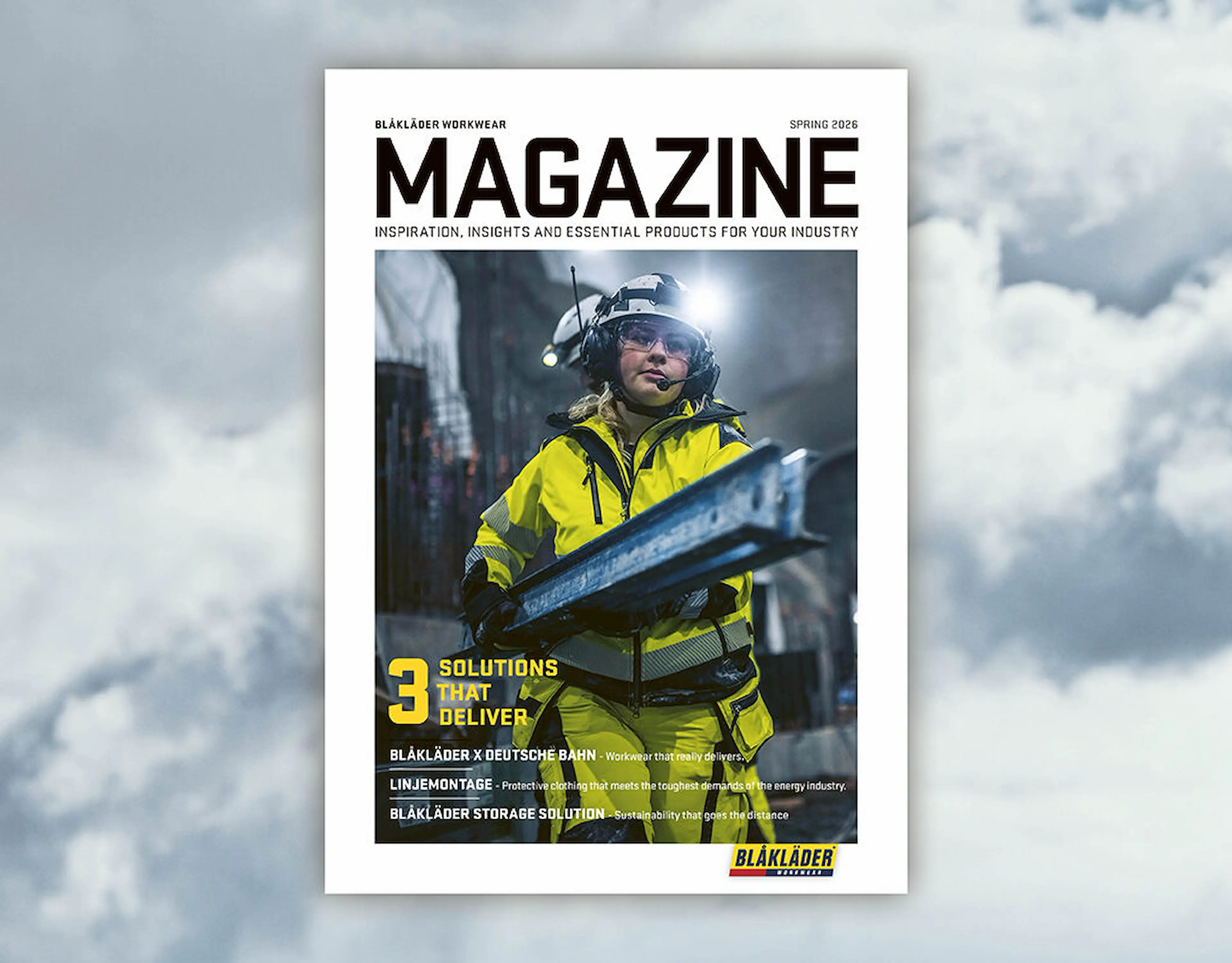 Magazine cover for Blåkläder Workwear (Spring 2026) featuring a construction worker in a high-visibility yellow jacket and helmet with headlamp, holding a metal beam in an industrial urban setting. Headline reads “3 Solutions That Deliver.”