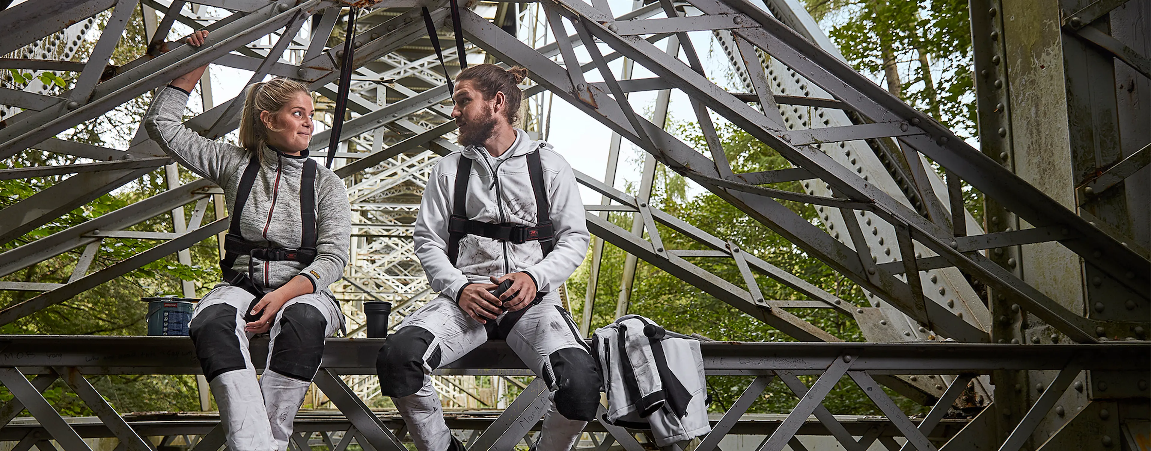 Malere som sitter under en bro i arbeidsklær fra Blåkläder