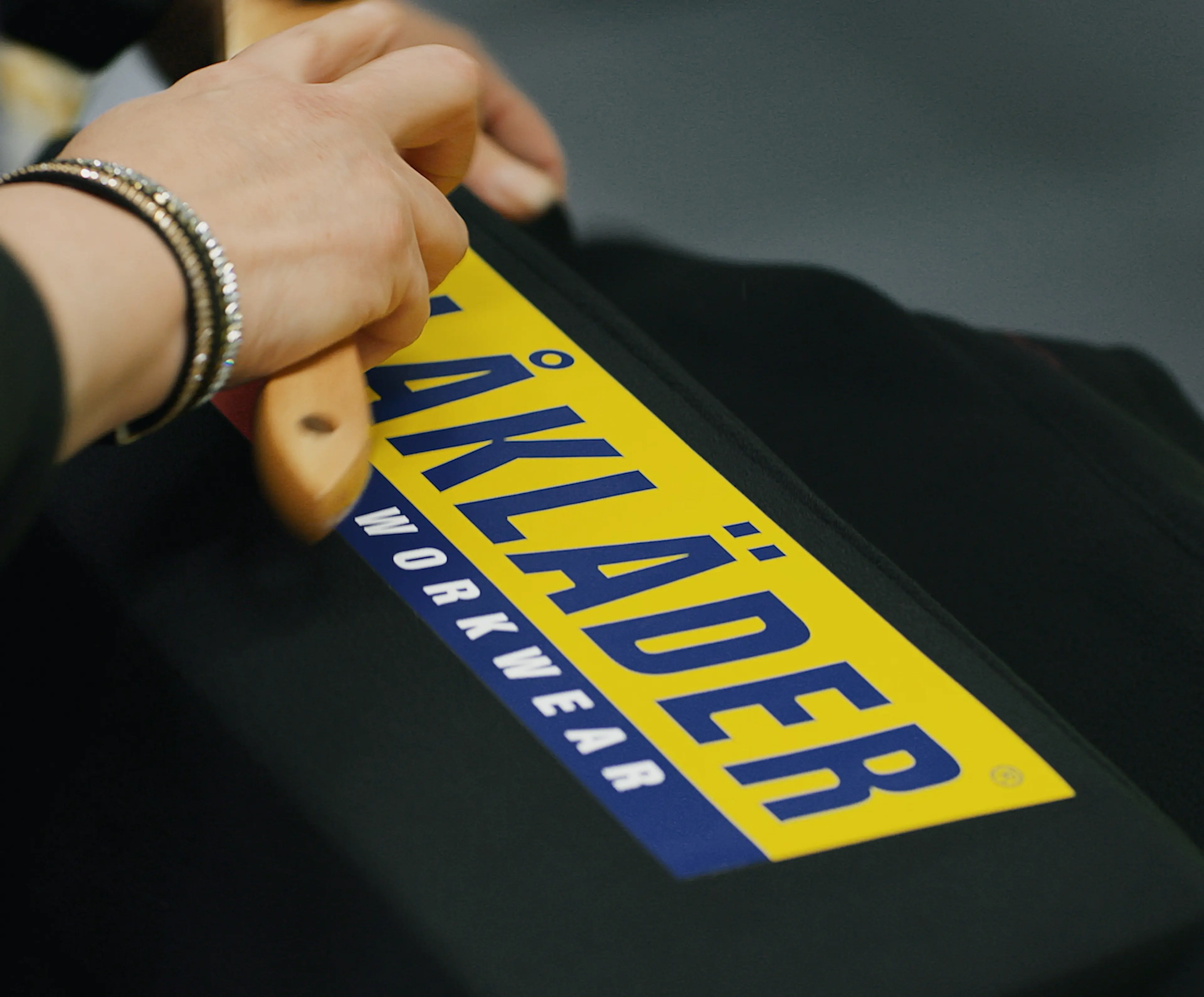 Blåkläder-ansatt trykker på logo på arbeidsklær